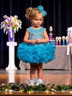 Girls turquoise beaded ruffle cupcake pageant dress on stage, front view